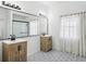 Stylish bathroom featuring dual vanities, a large mirror, and a glass-enclosed shower at 1404 Longville Cir, Tavares, FL 32778