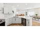 Open-concept kitchen offering white cabinetry, quartz countertops, and seamlessly flowing into the living spaces at 1404 Longville Cir, Tavares, FL 32778