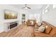 Cozy living room featuring comfortable leather sofas, a fireplace, and abundant natural light at 1404 Longville Cir, Tavares, FL 32778