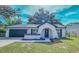 Charming single-story home featuring an arched entryway, manicured lawn, and attached two-car garage at 2220 Crystal Grove Ln, Lakeland, FL 33801