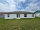 Back view of a house featuring double doors and a large backyard at 325 Ashley Loop, Davenport, FL 33837