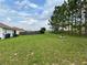 Spacious backyard with a wooden fence and neighboring houses visible at 325 Ashley Loop, Davenport, FL 33837