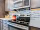 Modern kitchen with stainless steel appliances and stone backsplash at 592 Lake Smart Blvd, Winter Haven, FL 33881