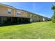 Backyard view of the home with green grass and enclosed patio at 721 Interlude Ln # 105, Orlando, FL 32824
