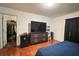 Spacious bedroom features wood floors, large dresser, television, walk-in closet, and modern decor at 721 Interlude Ln # 105, Orlando, FL 32824