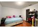 Bright bedroom with wood floors features a full bed and black shelving with modern decor at 721 Interlude Ln # 105, Orlando, FL 32824