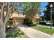 Exterior street view of townhomes shows lush landscaping, driveways, and attached garages at 721 Interlude Ln # 105, Orlando, FL 32824