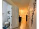 Hallway with light flooring and neutral colored walls leads to front door and full bathroom at 721 Interlude Ln # 105, Orlando, FL 32824