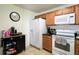 The kitchen shows white appliances, wooden cabinets, granite counters, and ample storage at 721 Interlude Ln # 105, Orlando, FL 32824