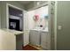 Convenient laundry room featuring a stacked washer and dryer with storage shelf at 721 Interlude Ln # 105, Orlando, FL 32824