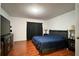Main bedroom features wood laminate floors and a dresser with a large TV at 721 Interlude Ln # 105, Orlando, FL 32824