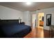 Main bedroom features a sleek black bed frame, warm wood floors, and a glimpse into the ensuite bathroom at 721 Interlude Ln # 105, Orlando, FL 32824