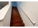 Wood staircase leading to upper level with white railings at 721 Interlude Ln # 105, Orlando, FL 32824