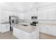 Modern kitchen boasts white cabinets, stainless steel appliances, and an island at 907 Heirloom Dr, Haines City, FL 33844