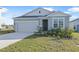 One-story house with gray siding, two-car garage, and landscaped front yard at 911 Heirloom Dr, Haines City, FL 33844