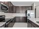 Modern kitchen with dark cabinetry, stainless steel appliances, and white countertops at 911 Heirloom Dr, Haines City, FL 33844