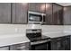 Sleek kitchen with dark cabinetry, stainless steel appliances, and white countertops at 911 Heirloom Dr, Haines City, FL 33844