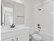 Bright bathroom features a white vanity, toilet, shower, and tub with black fixtures and tiled shower walls at 922 Heirloom Dr, Haines City, FL 33844