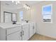 This bathroom features double sinks, sleek fixtures, a large mirror, and a window for natural light at 922 Heirloom Dr, Haines City, FL 33844