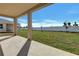 Covered patio looks out onto a spacious backyard with green grass and a bright blue sky at 922 Heirloom Dr, Haines City, FL 33844