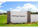 Attractive Heritage Square community entrance sign framed with stone pillars and lush landscaping at 922 Heirloom Dr, Haines City, FL 33844