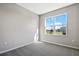 Bright bedroom with gray carpet and a large window at 930 Heirloom Dr, Haines City, FL 33844