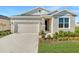 One-story home with neutral siding, landscaping, and a two-car garage at 930 Heirloom Dr, Haines City, FL 33844