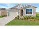 One-story home with neutral siding, landscaping, and a two-car garage at 930 Heirloom Dr, Haines City, FL 33844