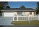 Ranch style home with white picket fence and attached garage at 267 Cranbrook Dr, Kissimmee, FL 34758