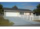 House with a long driveway and white picket fence at 267 Cranbrook Dr, Kissimmee, FL 34758