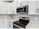 Modern kitchen with stainless steel appliances and white cabinets at 1706 Sugarbelle Cir, Mascotte, FL 34753