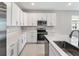 Modern kitchen with stainless steel appliances and white cabinets at 1706 Sugarbelle Cir, Mascotte, FL 34753