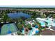 Stunning aerial view of resort-style amenities featuring a lazy river, pool, basketball court, and a scenic lake with fountain at 1921 Nice Ct, Kissimmee, FL 34747