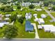 Aerial view of a blue home with an expansive lawn, surrounded by a quiet residential neighborhood at 435 Lantern Dr, Kenansville, FL 34739