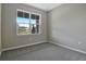 Simple bedroom with grey carpet and a large window at 1446 Maddie Berry Ln, Kissimmee, FL 34744