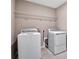 Functional laundry room with washer, dryer, and overhead shelving at 1446 Maddie Berry Ln, Kissimmee, FL 34744