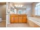 Bathroom boasts double sinks, wood cabinets, and a relaxing garden tub at 9532 Silver Buttonwood St, Orlando, FL 32832