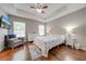 Main bedroom with wood floors, ceiling fan, and ensuite bathroom at 9532 Silver Buttonwood St, Orlando, FL 32832