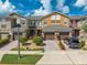 Three-story townhouses with brown garages, and landscaped yards at 9532 Silver Buttonwood St, Orlando, FL 32832