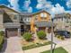 Three-story townhouses with brown garages, and landscaped yards at 9532 Silver Buttonwood St, Orlando, FL 32832