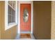 Inviting orange front door with a clover-shaped glass insert at 9532 Silver Buttonwood St, Orlando, FL 32832