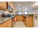 Well-lit kitchen with stainless steel appliances and wood cabinets at 9532 Silver Buttonwood St, Orlando, FL 32832