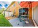 Small patio with table and chairs, umbrella, and adjacent AC unit at 9532 Silver Buttonwood St, Orlando, FL 32832