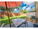 Mosaic-top patio table with chairs under an umbrella at 9532 Silver Buttonwood St, Orlando, FL 32832