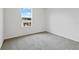 Bright bedroom with large window and grey carpeting at 1416 Maddie Berry Ln, Kissimmee, FL 34744