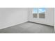 Well-lit bedroom featuring grey carpeting and two windows at 1416 Maddie Berry Ln, Kissimmee, FL 34744