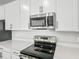 Stainless steel range and microwave in modern kitchen at 1416 Maddie Berry Ln, Kissimmee, FL 34744