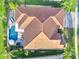 Backyard aerial view featuring a tiled roof, swimming pool, outdoor seating, and beautiful landscaping at 2891 Swoop Cir, Kissimmee, FL 34741