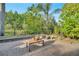 Spacious backyard with lush landscaping, a wooden coffee table, and plenty of room for outdoor activities and relaxation at 2891 Swoop Cir, Kissimmee, FL 34741