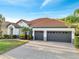 Lovely single-story home featuring a tile roof, a three-car garage, and a paved driveway at 2891 Swoop Cir, Kissimmee, FL 34741